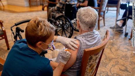 A healthcare worker administers a third dose of the Pfizer-BioNTech Covid-19 vaccine at a senior living facility in Worcester, Pennsylvania.