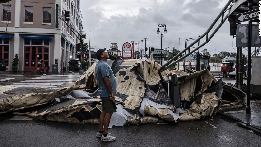 A man looks up next to a section of roof that was ripped off a building in the French Quarter of New Orleans on Monday.