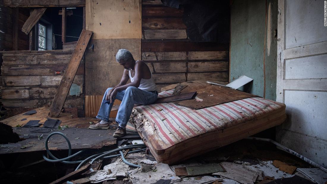 Theophilus Charles sits inside his damaged home in Houma on August 30.