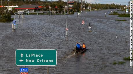 A boat carries people in a flooded area of Highway 51 near LaPlace, Louisiana, on Monday morning.