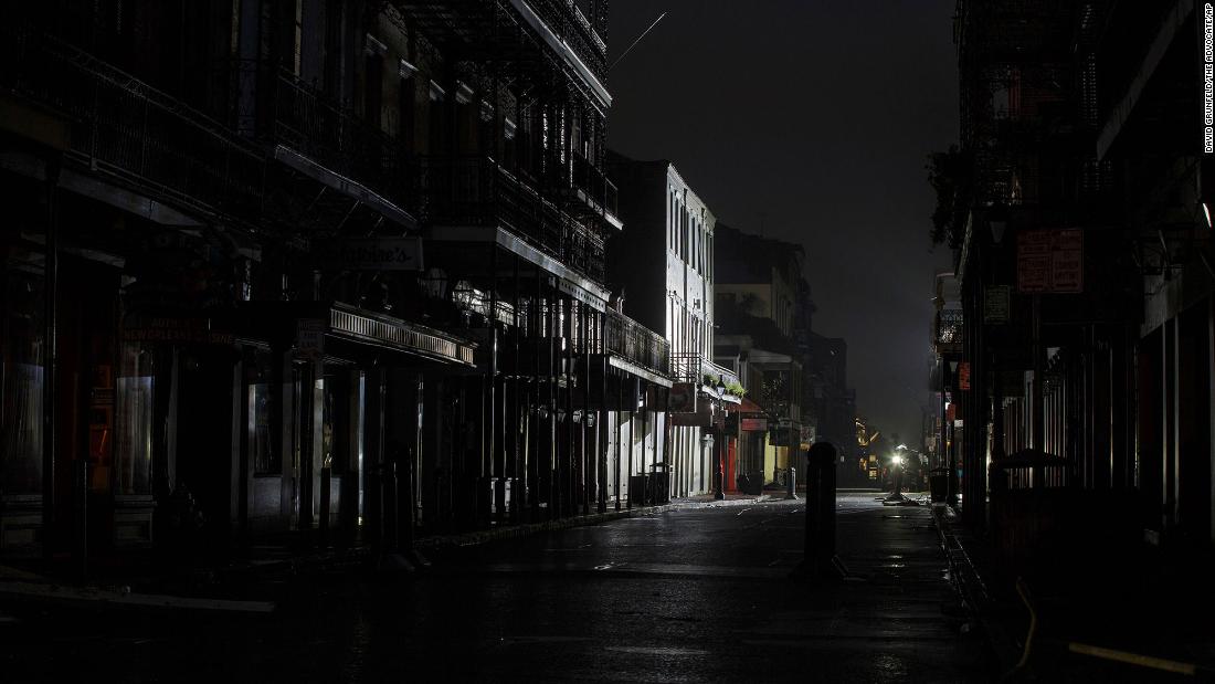 Lights from a TV broadcast illuminate an otherwise dark Bourbon Street in New Orleans on August 30.