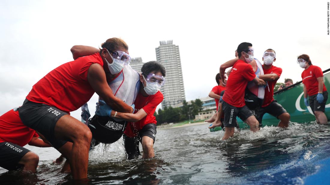 Athletes are helped out of the water during a triathlon on August 29.