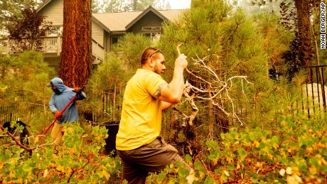 James Campos clears vegetation from a neighboring lot to protect his house, in background, as the Caldor Fire approaches South Lake Tahoe on August 30, 2021.