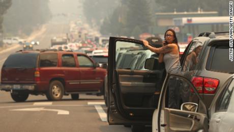 A woman talks on her phone while stopped in heavy traffic on Hwy 50 as people evacuate ahead of the Caldor Fire on August 30, 2021, in South Lake Tahoe, California. 