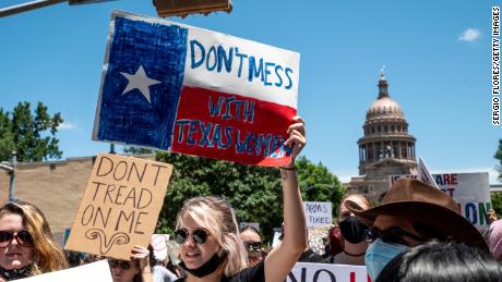 Protesters hold up signs as they march down Congress Avenue at a protest outside the Texas state capitol on May 29, 2021, in Austin, Texas. 