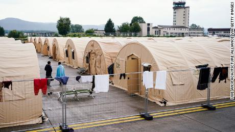 30 August 2021, Rhineland-Palatinate, Ramstein-Miesenbach: People evacuated from Afghanistan stand between tents at Ramstein Air Base.  The US also uses its military base in Ramstein, Palatinate, as a hub for the evacuation of people seeking protection and local forces from Afghanistan. Photo: Uwe Anspach/dpa (Photo by Uwe Anspach/picture alliance via Getty Images)