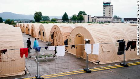 Des personnes évacuées d'Afghanistan se tiennent entre des tentes à Ramstein.