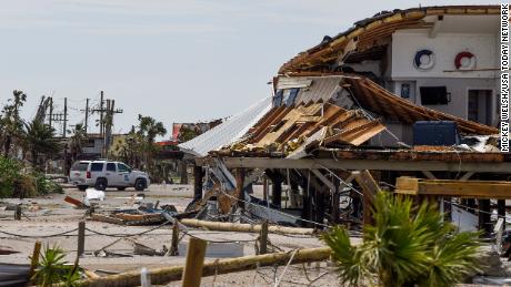 A Louisiana State Trooper keeps watch over damaged homes on Grand Isle on Tuesday.