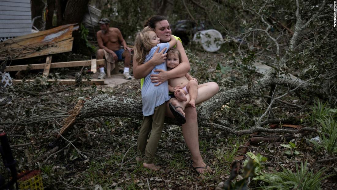 Tiffany Miller embraces her daughter Desilynn, left, and godchild Charleigh after the family returned to their destroyed home in Golden Meadow, Louisiana, on Wednesday, September 1.