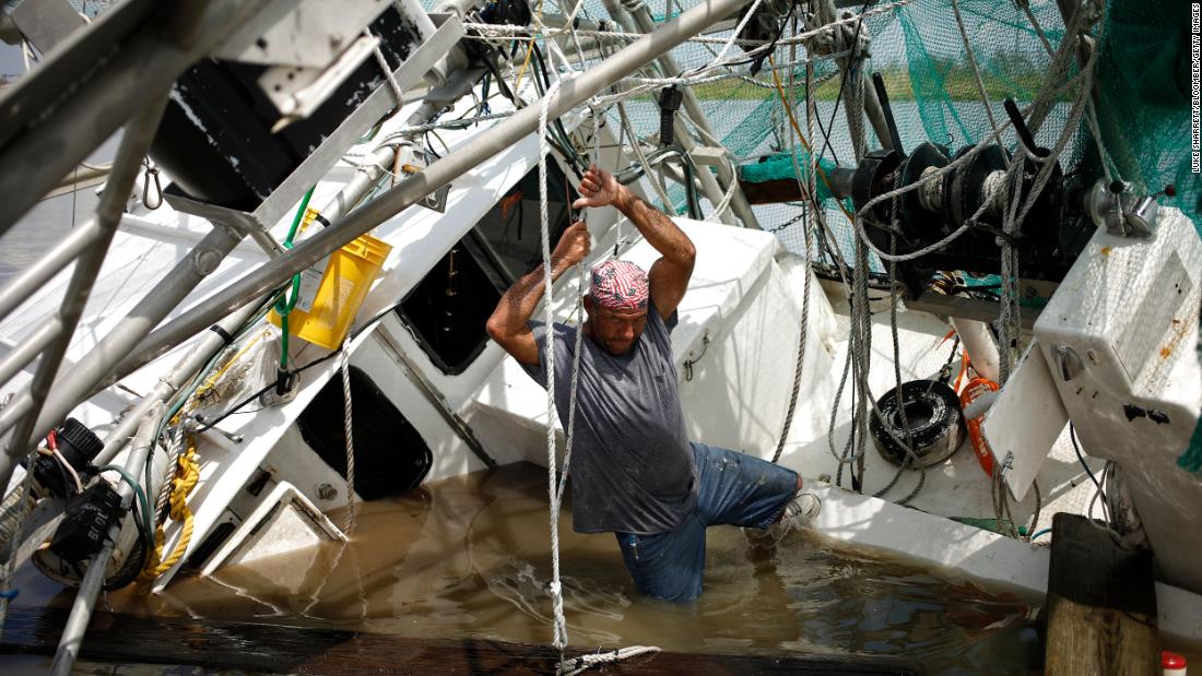 A shrimper works to salvage his partially submerged boat in Golden Meadow on August 31.