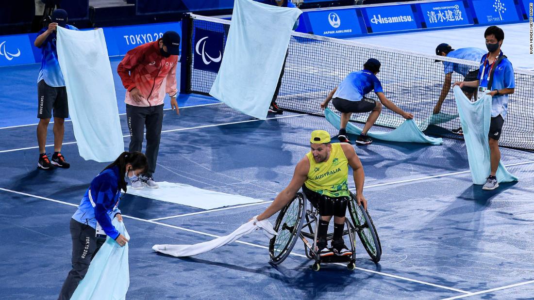 Australia&#39;s Dylan Alcott helps volunteers dry the court before his wheelchair tennis match on September 1.