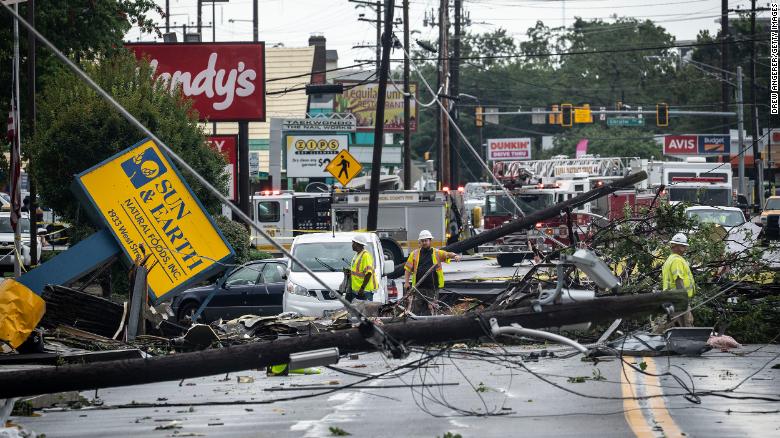 Comcast utility workers survey the damage from a tornado on West Street in Annapolis, Maryland.