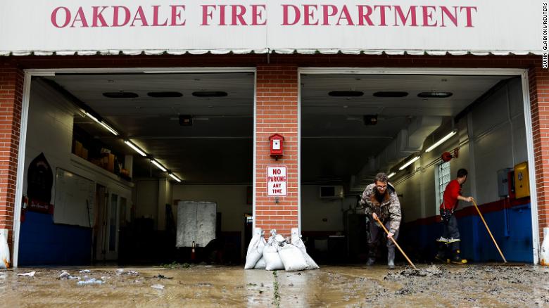 Members of the Oakdale Fire Department clear debris from their station after heavy rains in Oakdale, Pennsylvania, on September 1.