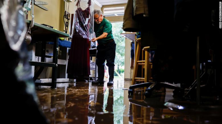 Sergio Rossi, owner of Sergio Tailoring, covers flood-damaged clothing at his shop in Oakdale, Pennsylvania, on September 1.