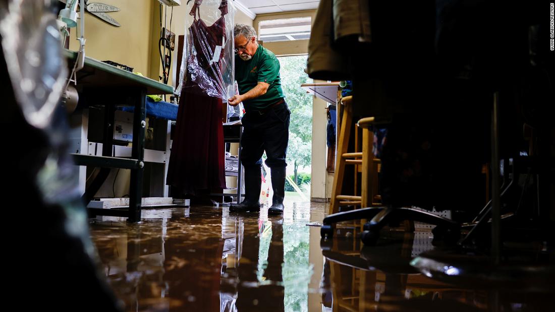 Sergio Rossi, owner of Sergio Tailoring, covers flood-damaged clothing at his shop in Oakdale, Pennsylvania, on September 1.