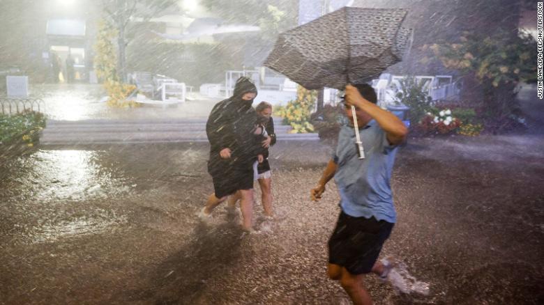 People navigate heavy rains and flooded walkways at the Billie Jean King National Tennis Center in New York City on September 1.