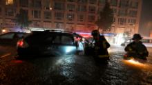 Members of the FDNY rescue a woman from her stalled car due to flash flooding in the New York, New York, Wednesday night, September 1, 2021. 
