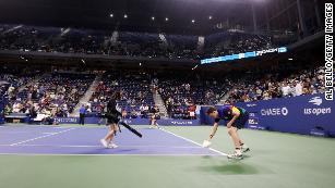 Crew members do their best to dry the court.