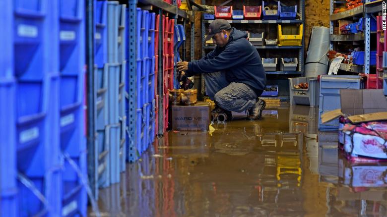 A United Automatic Fire Sprinkler employee helps clean up on September 2 after the business flooded in Woodland Park, New Jersey.