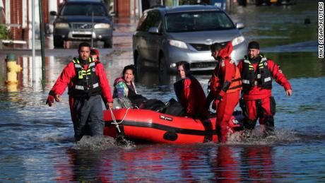First responders pull local residents in a boat in Mamaroneck, New York, on Thursday.