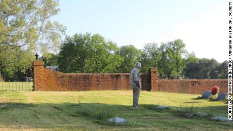 Bicentennial organizer Frank Delano examines the slave cemetery at Nomini Hall in 2014. 
