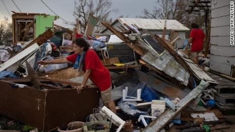 Les sœurs jumelles Bridget et Rosalie Serigny, 66 ans, recherchent mercredi des objets personnels stockés dans leur hangar détruit à Golden Meadow, en Louisiane.