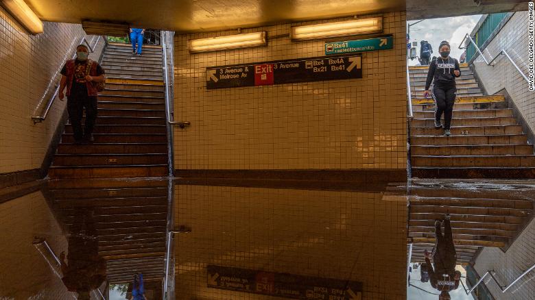 People walk into a flooded subway station in New York City. Heavy rainfall from the remnants of Hurricane Ida disrupted service, dumping more than 3 inches of rain in the span of an hour.