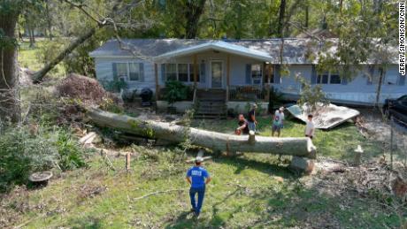 Volunteers from nearby churches came to help chop up the nearly 100 foot oak tree that killed Dennis Duplessis during Hurricane Ida.