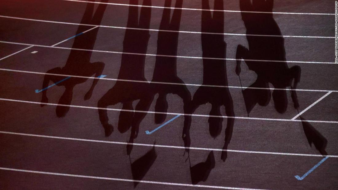 Participants&#39; shadows are seen on the track during the closing ceremony.
