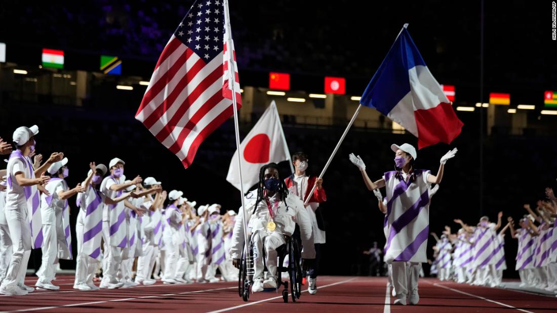 Flag bearers for the United States, Japan and France enter the stadium during the closing ceremony.