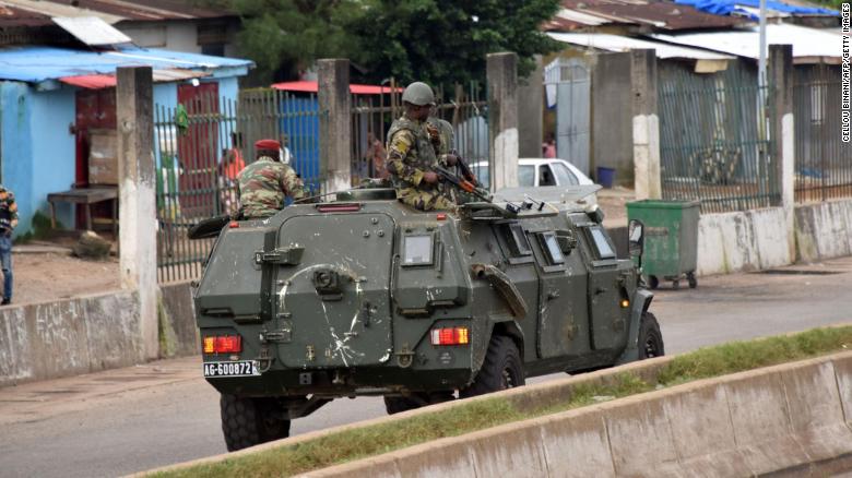Members of Guinea&#39;s armed forces drive through the central neighborhood of Kaloum, in Conakry, on September 5.