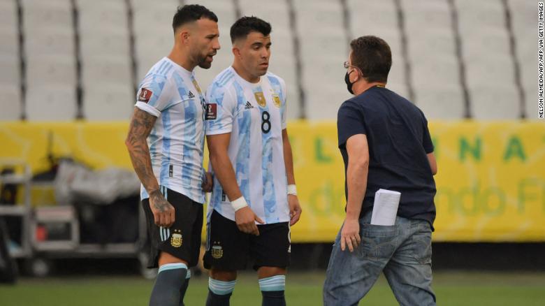 An employee of Brazil&#39;s National Health Surveillance Agency (Anvisa) argues with Argentina&#39;s Nicolas Otamendi (L) and Marcos Acuna.
