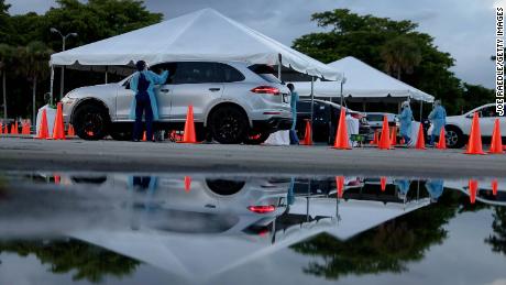 Healthcare workers at a 24-hour drive-thru site set up by Miami-Dade and Nomi Health in Tropical Park to administer Covid-19 tests.