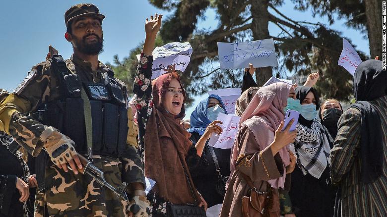 A Taliban fighter stands guard as Afghan women shout slogans during a protest in Kabul on Tuesday.