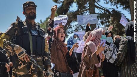 A Taliban fighter stands guard as Afghan women shout slogans during a rally near the Pakistan embassy in Kabul on September 7.