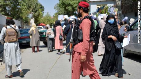 Taliban fighters watch as Afghan women take part in an anti-Pakistan demonstration near the Pakistan embassy in Kabul on Tuesday.