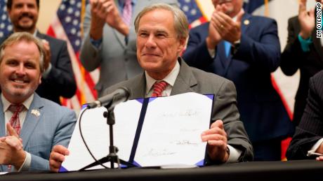 Texas Gov. Greg Abbott shows off Senate Bill 1, also known as the election integrity bill, after he signed it into law on Sept. 7, 2021.