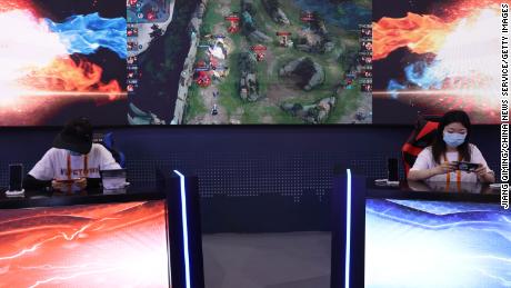 Visitors playing "Arena of Valor," a multiplayer online battle arena game, at Tencent's booth during a trade fair in September in Beijing.