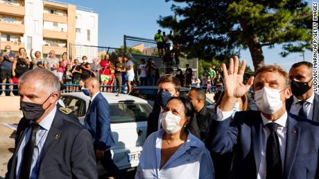 President Emmanuel Macron waves to locals in the Bassens district next to Marseille&#39;s Mayor Benoit Payan (center) during a visit to the southern port city on September 1, 2021.