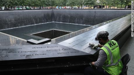NEW YORK, NEW YORK - SEPTEMBER 08: Polishing work is done on the bronze parapets surrounding the twin Memorial pools where the names of the 2,983 names of the men, women, and children killed in the attacks of September 11, 2001 and February 26, 1993 are inscribed at the 9/11 Memorial and Museum on September 08, 2021 in New York City. Twenty years after two aircraft hijacked by 10 al-Qaeda terrorists flew into the North and South Towers of the World Trade Center, the 16-acre site is now a memorial to the 2,606 civilians, firefighters, and law enforcement officers who died in the towers and in the surrounding area and the 147 civilians who were aboard the airliners. (Photo by Chip Somodevilla/Getty Images)