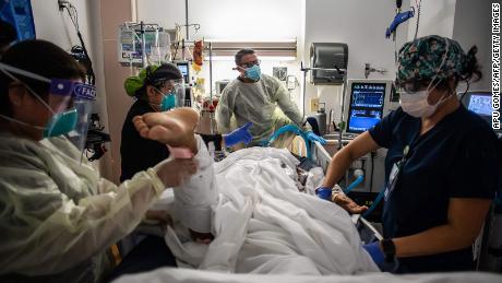 Health care workers attend to a patient with Covid-19 at the Cardiovascular Intensive Care Unit at Providence Cedars-Sinai Tarzana Medical Center in Tarzana, California.
