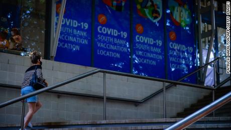 A woman walk past signage at a Covid-19 vaccination hub in Brisbane, Queensland, on August 17.