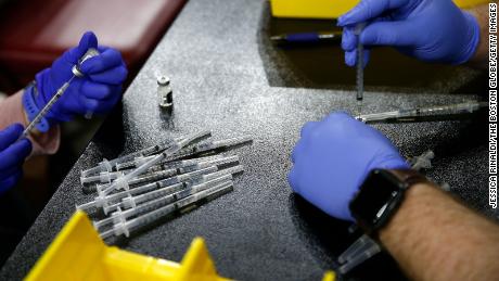 Boston, MA - April 26: Lauren Kehlenbach, RN (L) and Brandon Bessette, RN each draw up a dose of the Pfizer-BioNTech COVID-19 vaccine inside Boston Colleges Conte Forum in Boston on April 26, 2021. (Photo by Jessica Rinaldi/The Boston Globe via Getty Images)