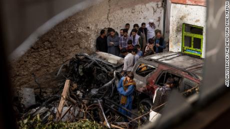 Relatives and neighbors inspect damage in the cramped courtyard of a house in Kabul, Afghanistan on Monday, Aug. 30, 2021, from what they said was a U.S. drone strike Sunday. The strike killed Zemari Ahmadi. U.S. officials say they struck an ISIS-K vehicle. His family says it was the car he used to deliver food to refugee camps. (Jim Huylebroek/The New York Times)
