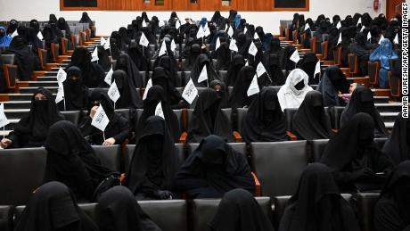 Veiled students hold Taliban flags as they listen a speaker before a pro-Taliban rally at the Shaheed Rabbani Education University in Kabul on September 11.