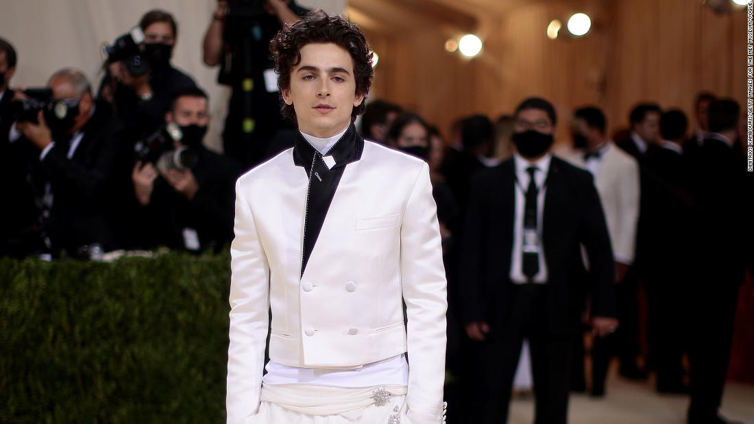&quot;Dune&quot; star Timothée Chalamet mixed streetwear and black-tie with a shrunken white-satin suit jacket and billowing white pants, by Haider Ackerman, tucked into a pair of white Converse sneakers. Underneath, he wore a layer of Rick Owens.