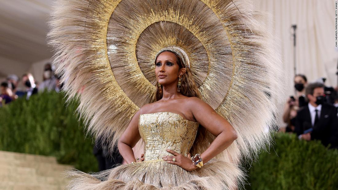 Supermodel Iman turned heads in a dramatic feathery headdress from Harris Reed with a matching tiered skirt over a glittering gold bell-bottom bodysuit.