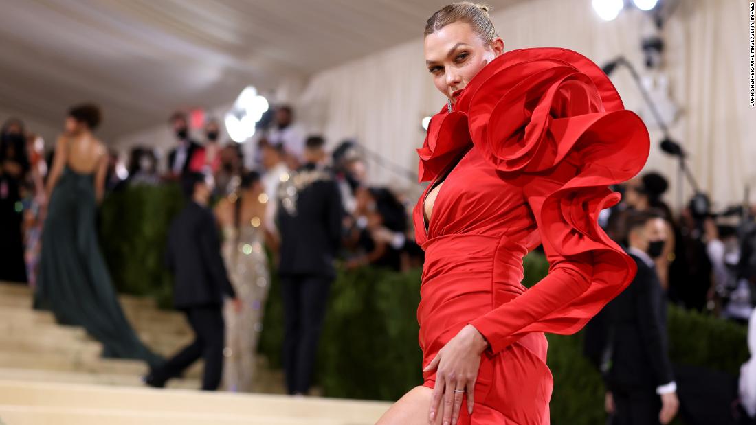 Karlie Kloss wore a bold red Carolina Herrera gown with striking structural details. She also carried a clutch detailed with a large floral rosette, in keeping with the design of her dress.
