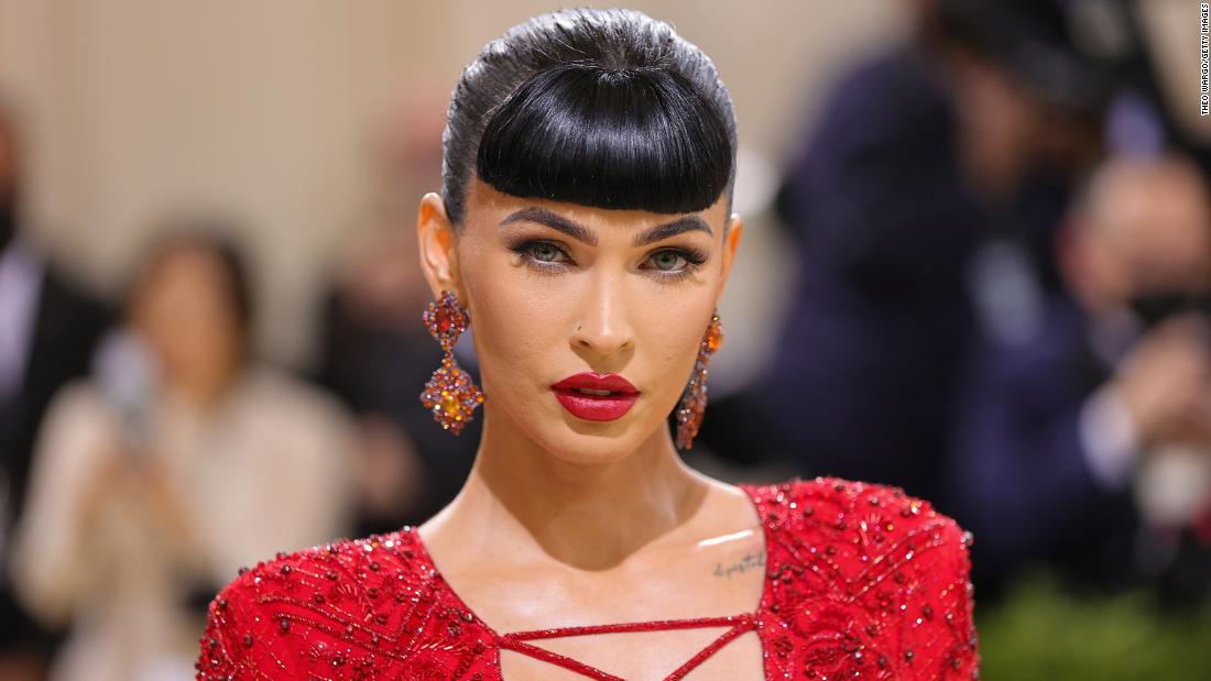 Actress Megan Fox sported pinup-style bangs in a daring red Dundas dress with a lace-up plunging v-neck and a high slit. According to the label&#39;s press release, the outfit was inspired by Art Deco aesthetics.