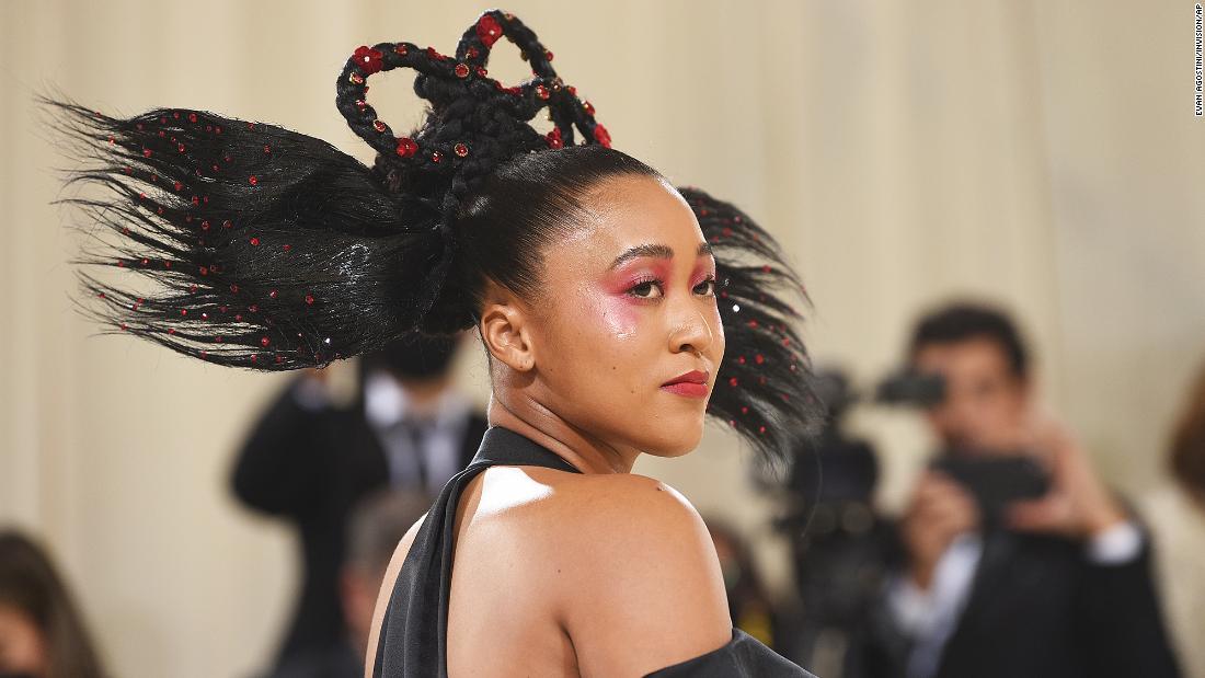 Naomi Osaka brought her Japanese and Haitian background together in an ensemble by Louis Vuitton. Her sister Mari Osaka, a fashion designer, worked with creative director Nicolas Ghesquirre to create the look which incorporated a Japanese obi belt and ruffles. On Instagram, Mari said the outfit referenced Haitian Quadrille dresses.